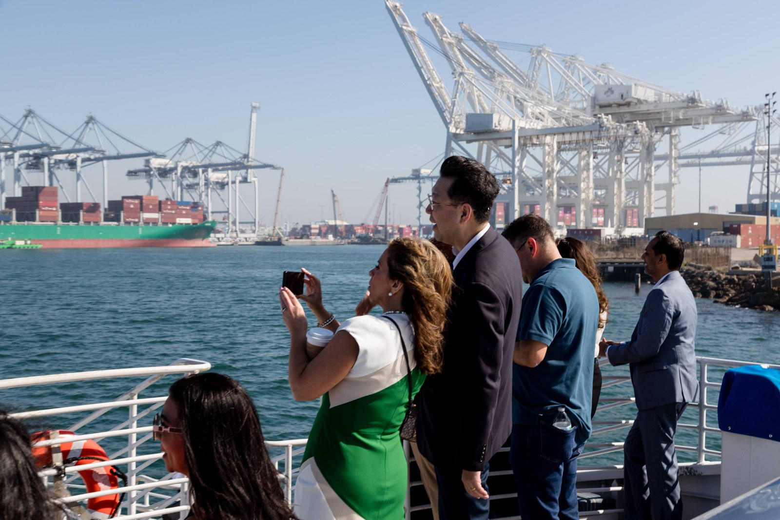 Chamber guests view port cranes and shipping terminals from the harbor-tour boat